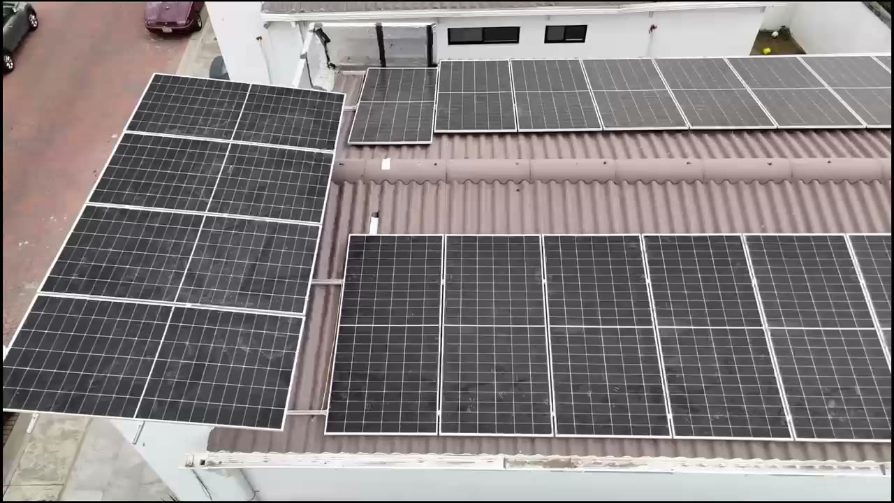 Vista aérea de paneles sobre una cubierta ondulada y la losa contigua