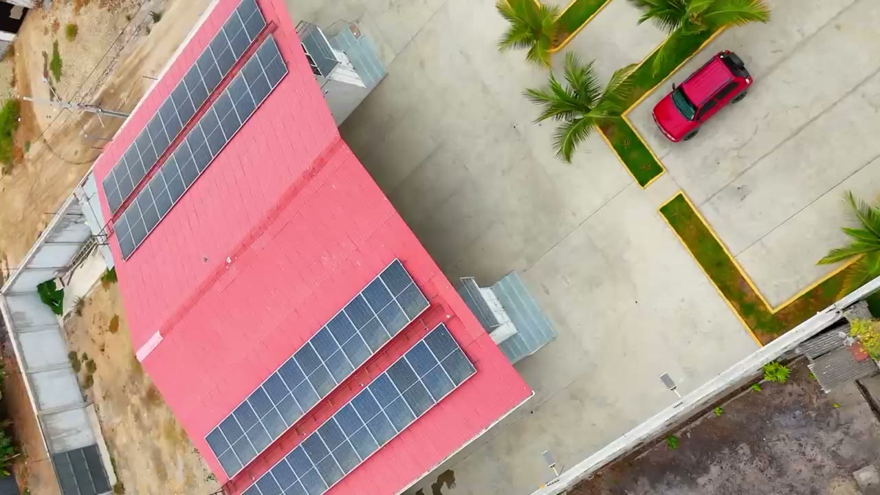 Vista aérea de una nave de cubierta metálica con paneles y su patio de maniobras